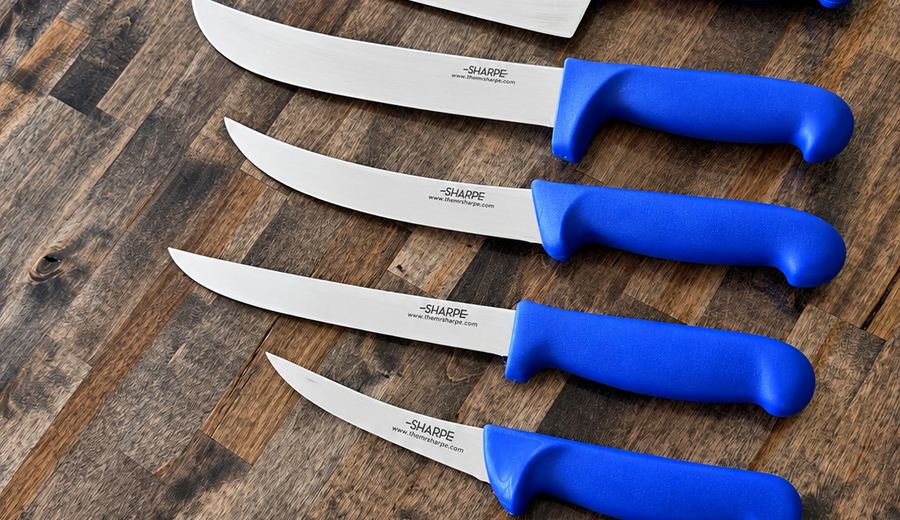 A row of blue-handled Mr. Sharpe kitchen knives on a wooden table